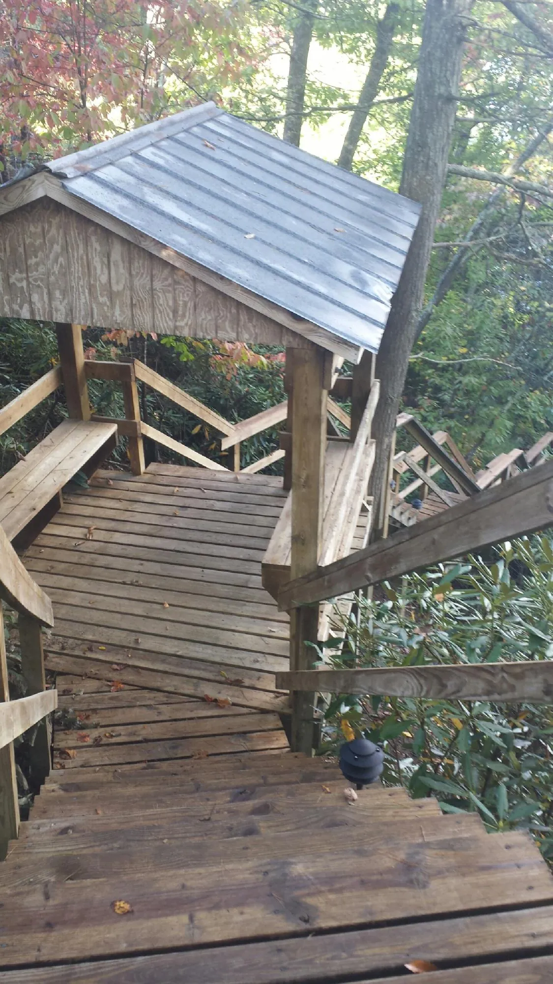 Metal roofed shelter over wooden steps on a wooded walkway — Skylight Repair & Installation work by our crew in Armonk