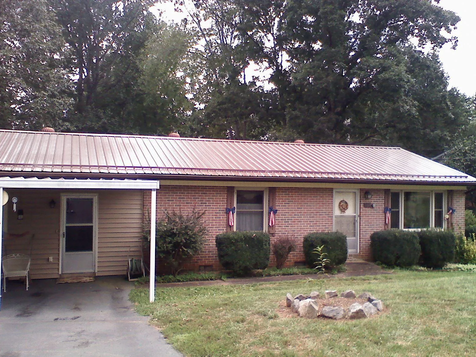 Bronze metal roof and carport on a brick ranch home — Roof Repair work by our crew in Armonk